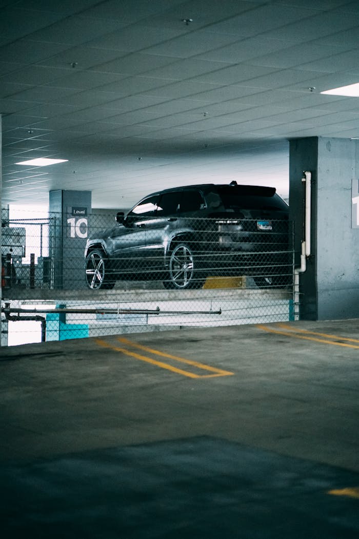 A sleek black car parked in an urban multi-level garage, showcasing modern transportation.